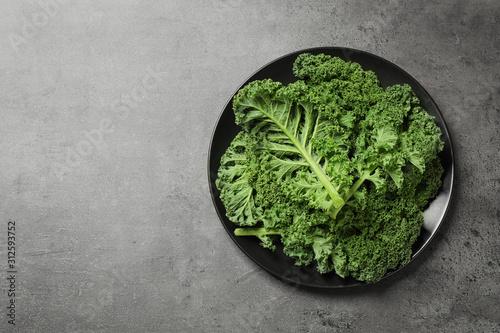 Fresh kale leaves on grey table  top view. Space for text