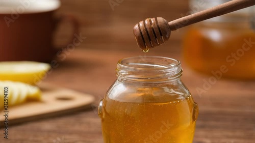 Cinemagraph- Drops of honey dripping in the jar with honey. Motion Photo.