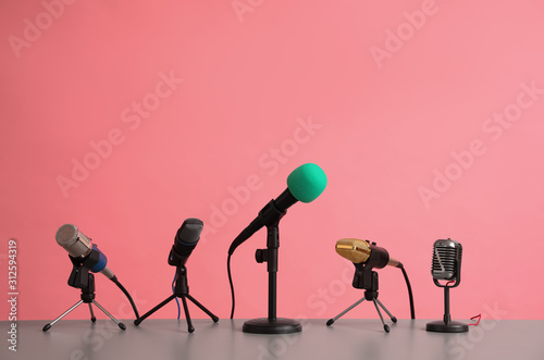 Microphones on table against pink background. Journalist's work