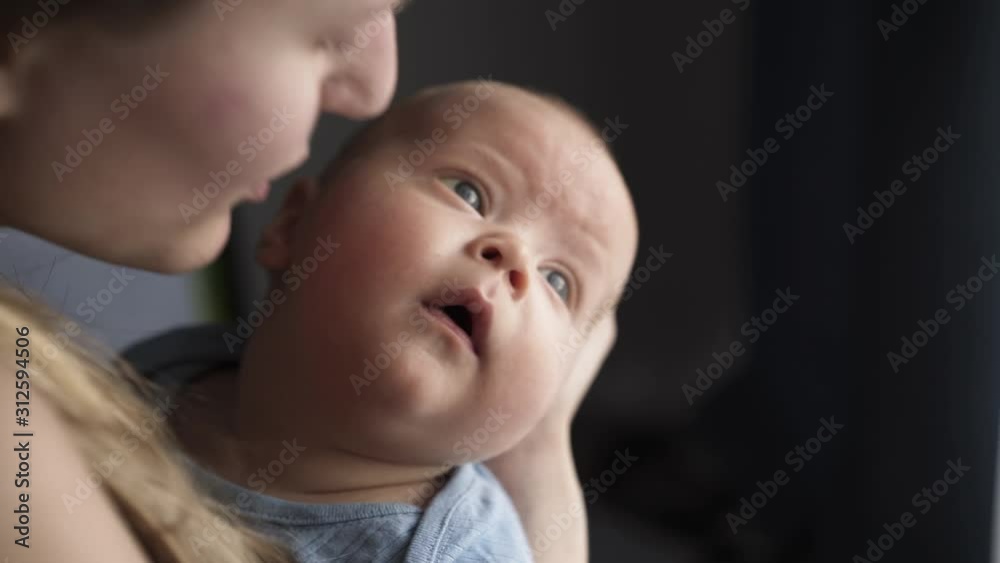 Portrait of admiring newborn baby in mother embraces Portrait of admiring newborn baby in mother embraces