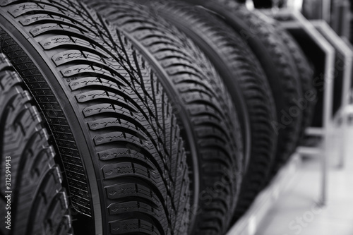 Car tires on rack in auto store, closeup © New Africa