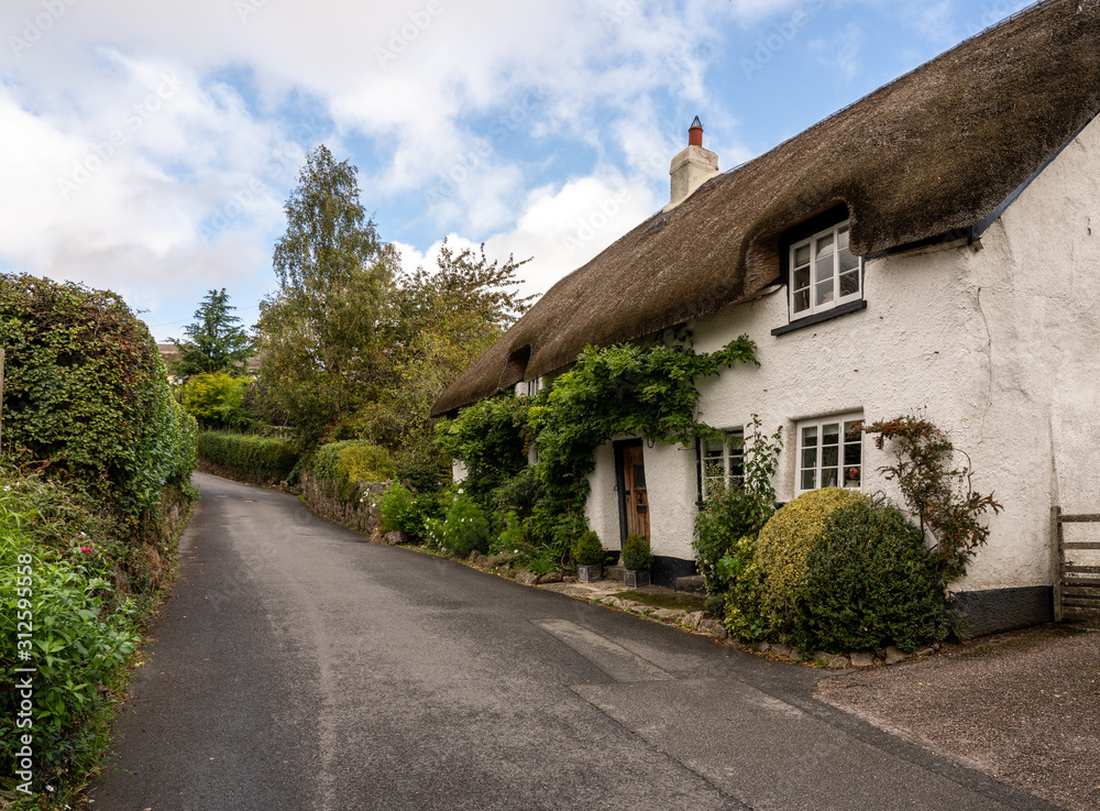 Stone home with thatched roof on small lane in the pretty Devon village of Dunsford Stone home with thatched roof on small lane in the pretty Devon village of Dunsford