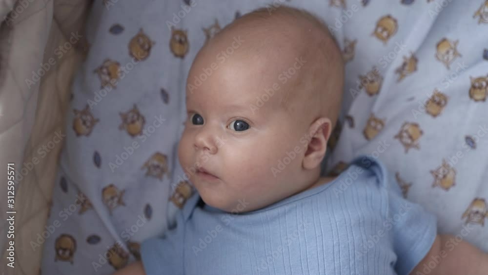Newborn baby lying in cradle and looking on camera