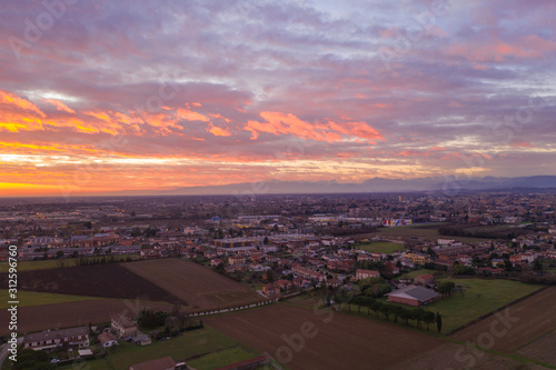 sunset over a small city on a background of mountains view from a drone