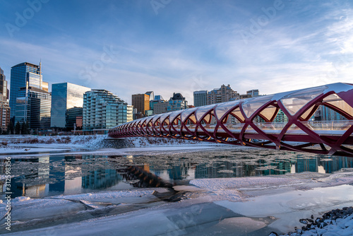 Evening skyline view along the Bow River in Calgary, Alberta. Peace Bridge visible. 