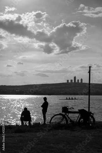 Hombres, bicicleta y lago.