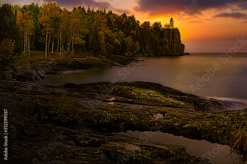 lighthouse on cliff at sunrise