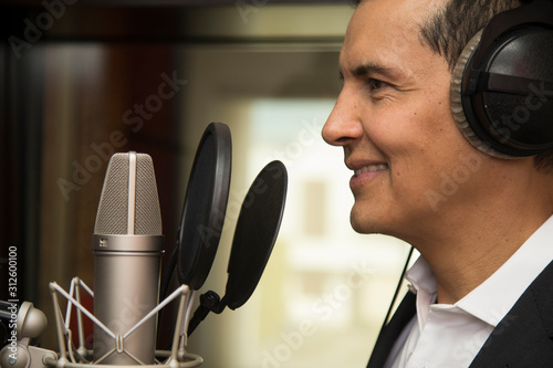 actor and radio announcer with headphones and microphone working film dubbing, performing radio spot and singing