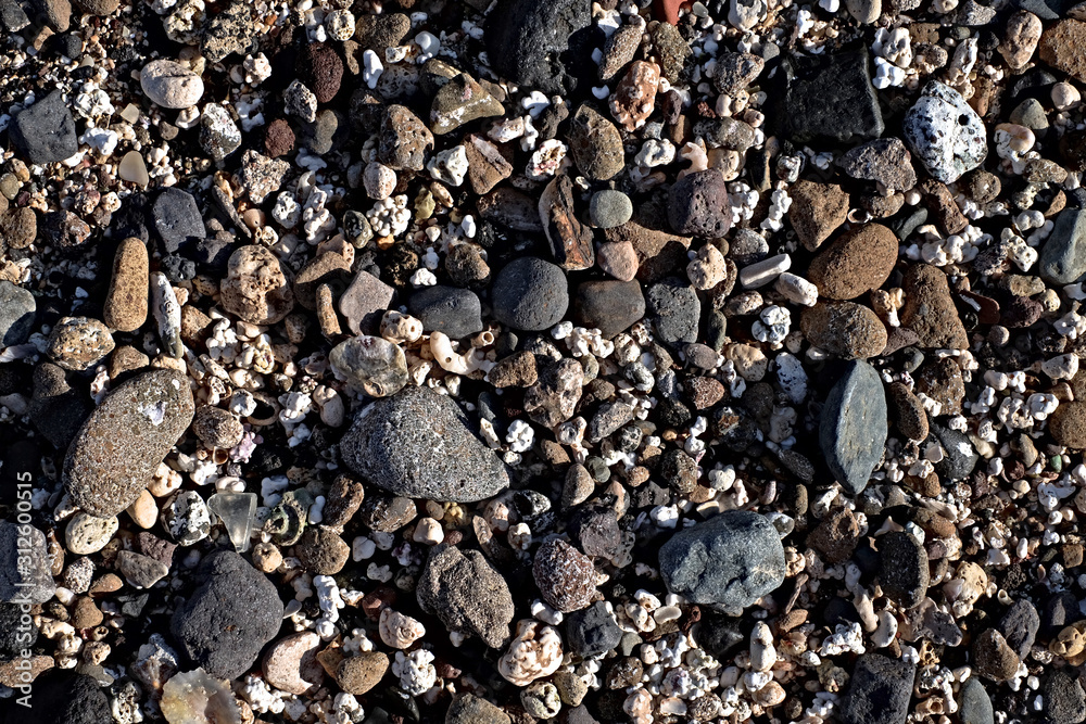 Pattern of white, gray and black assorted beach stones, low contrast and low saturation image. Pattern of white, gray and black assorted beach stones, low contrast and low saturation image.