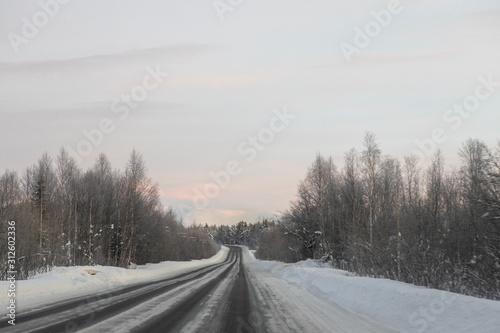 Winter road in the middle of snowy forest