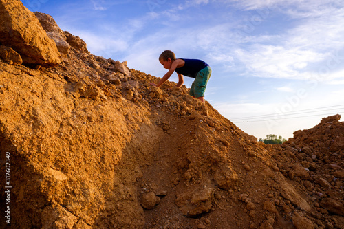 Child on a mountain climbing it. © Joaquin Corbalan