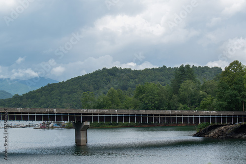 A railroad bridge in the distance with a river flowing underneath in the mountains of North Carolina.