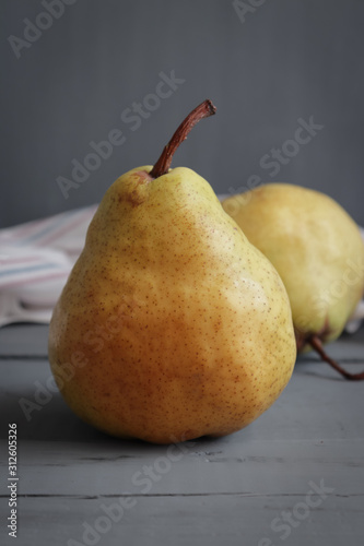 two green pears on a dark gray rustic table