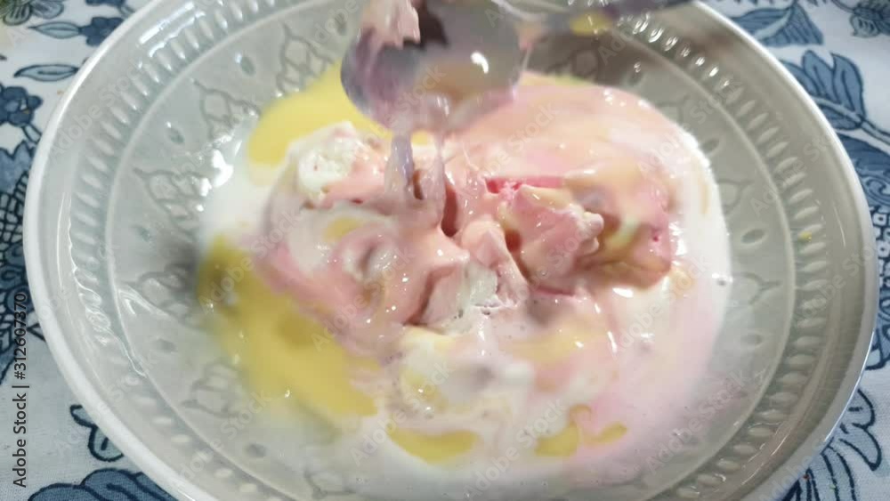 Strawberry, vanilla and black current flavored ice cream with yellow vanilla custard topping, delicious sunday dessert being scooped with stainless steel spoon in porcelain bowl. Strawberry, vanilla and black current flavored ice cream with yellow vanilla custard topping, delicious sunday dessert being scooped with stainless steel spoon in porcelain bowl.