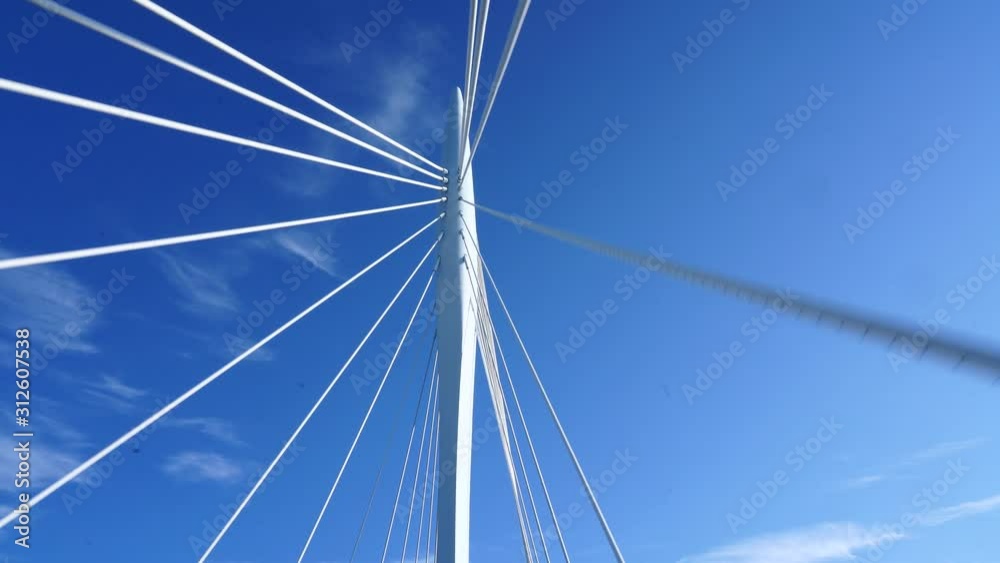 Driving through the beautiful white architecture suspension bridge of Kanaleneiland, Netherlands - Wide rolling shot Driving through the beautiful white architecture suspension bridge of Kanaleneiland, Netherlands - Wide rolling shot