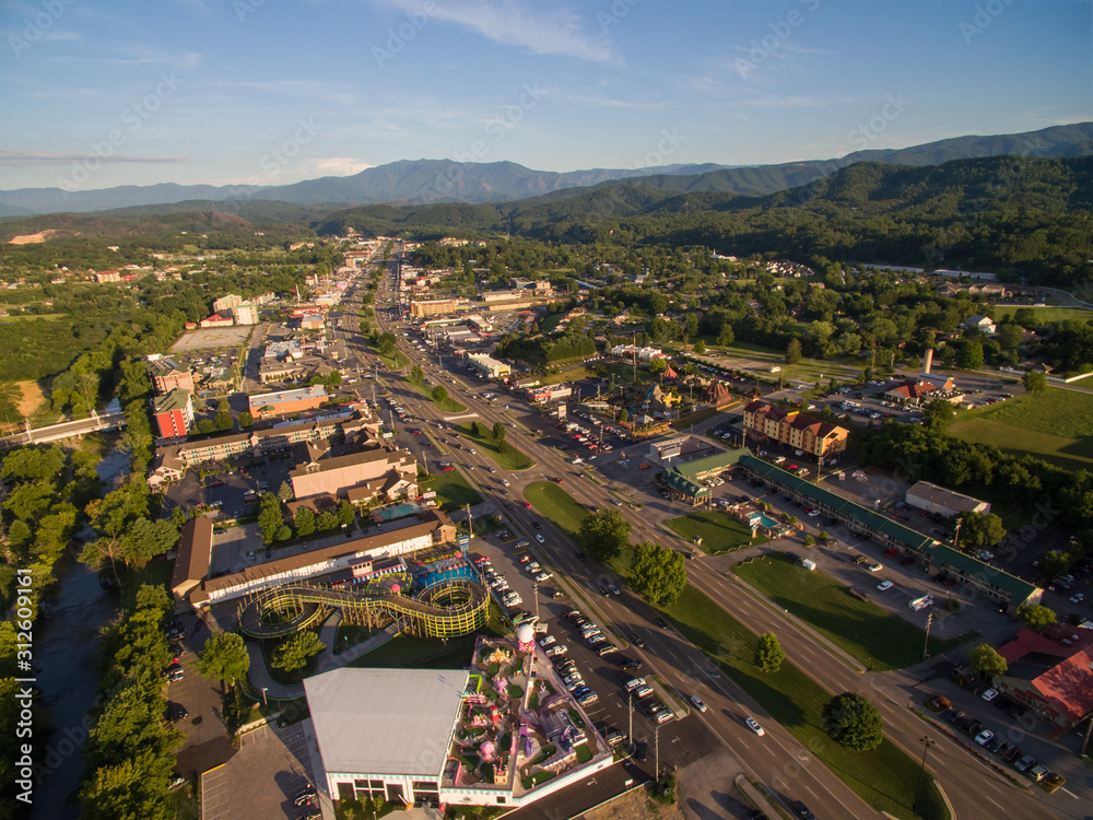The setting sun cast bright highlights on the various attractions of Pigeon Forge Tennessee. A drone, birds eye, aerial angled view.