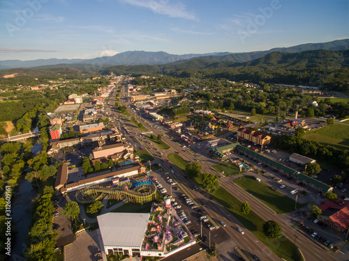The setting sun cast bright highlights on the various attractions of Pigeon Forge Tennessee. A drone, birds eye, aerial angled view.