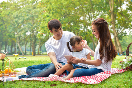 portrait of happy Asian family with picnic meal in relaxing day in garden, Asian family concept