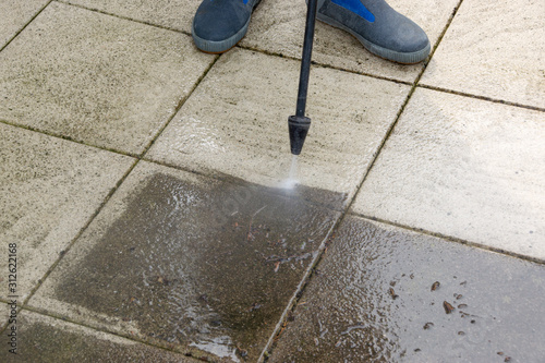 Outdoor floor cleaning with high pressure water jet. Man in rubber boots © kelifamily