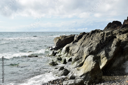 seawaves pounding rock formation on ocean waterfront