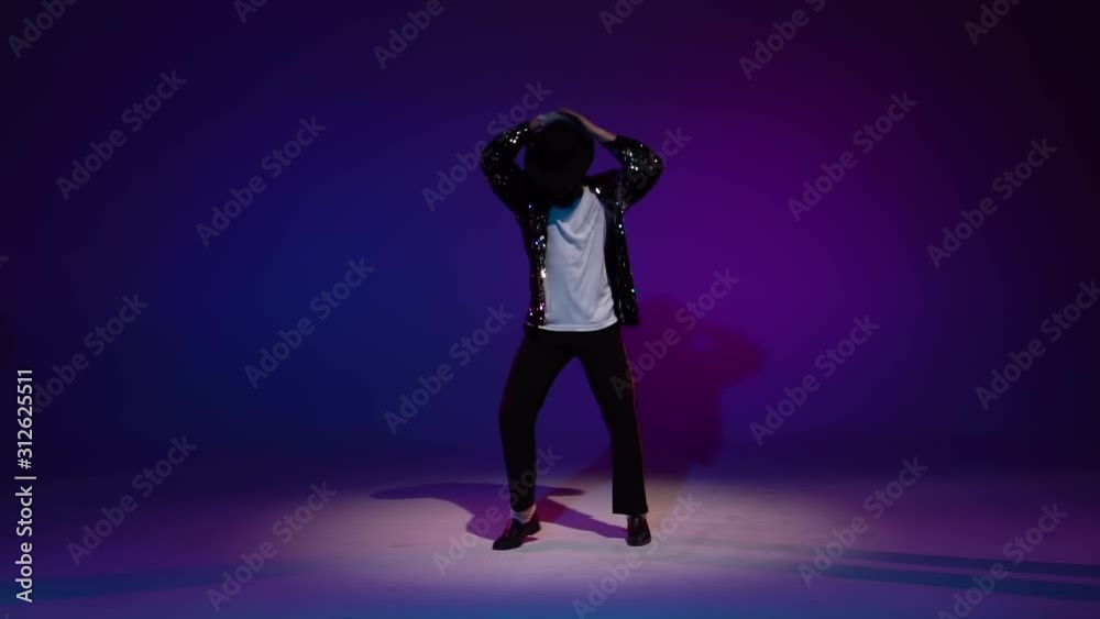 Young stylish man dancing, spotlight on a blue background. Close up, slow motion. Young stylish man dancing, spotlight on a blue background. Close up, slow motion.