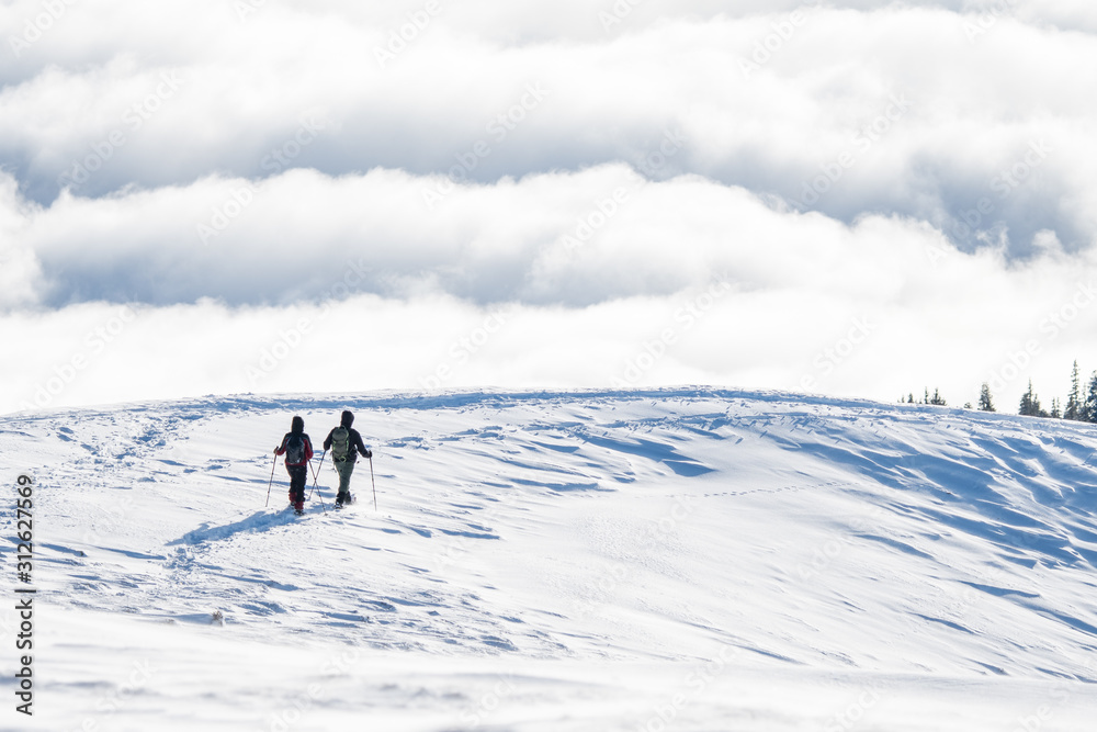 couple of snowshoe hikers in front of a sea of fog