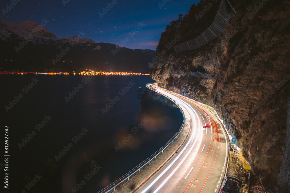 lighttrails of a s-curved street along Lake Thun during the Blue hour
