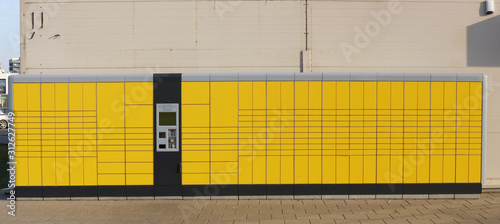 Self service very long yellow modern standard city parcel terminal installed near city market photo