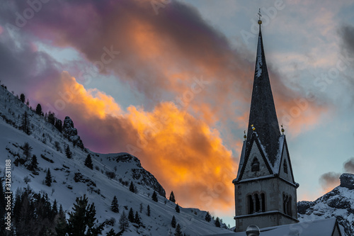 Photo Church steeple with snowy mountain and clouds at sunset