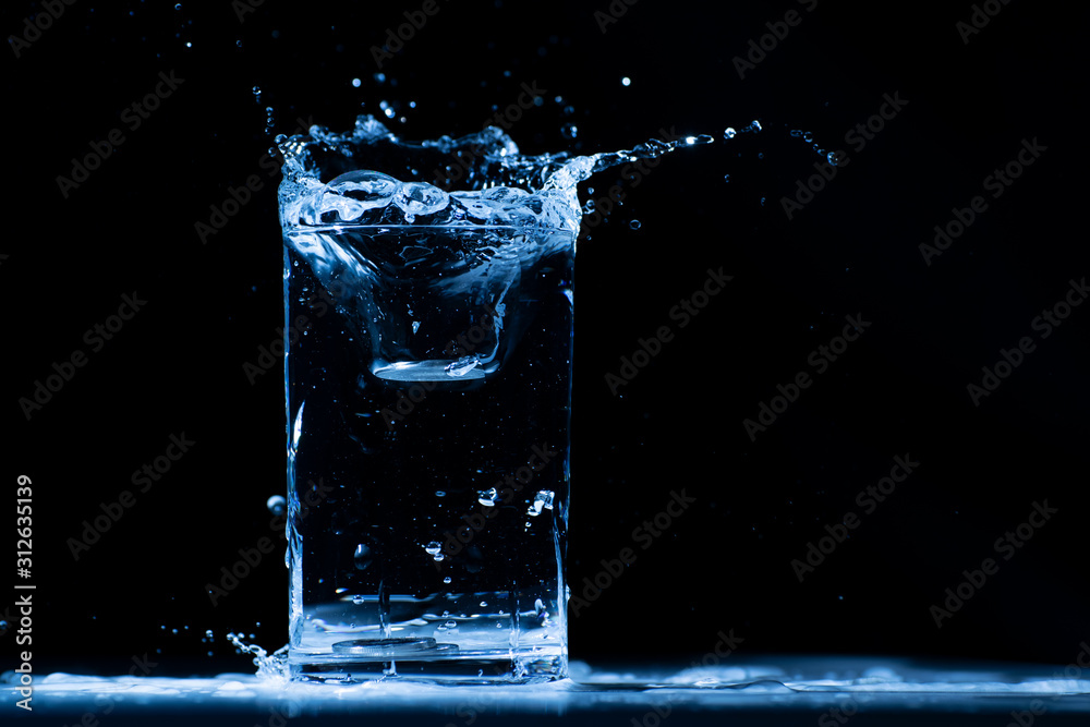 Pour water into glass on black background. Pour water into glass on black background.