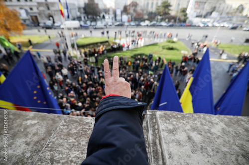 Fotografi People show the Victory Sign from the balcony where Nicolae Ceausescu held his last speech during the Romanian anti communist revolution in 1989