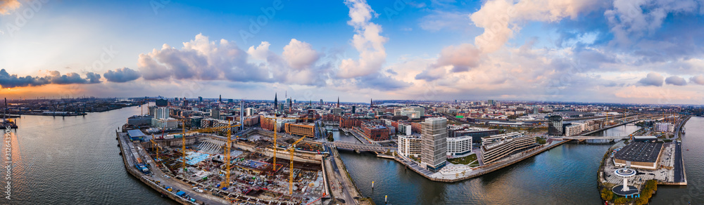 Aerial drone panoramic view of port of Hamburg from above during sunset with dramatic stormy clouds over historical city center