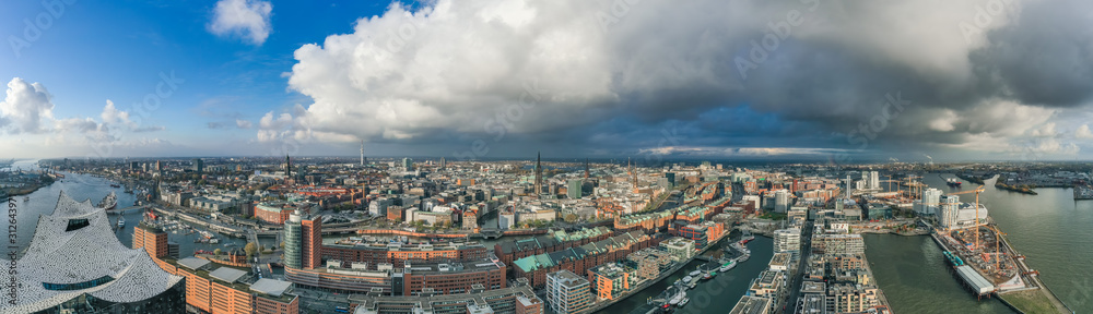 Aerial drone panoramic view of port of Hamburg from above before sunset with dramatic stormy clouds