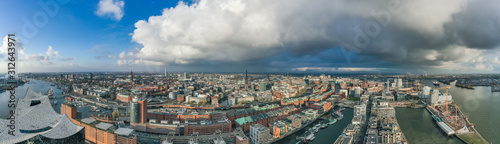 Aerial drone panoramic view of port of Hamburg from above before sunset with dramatic stormy clouds