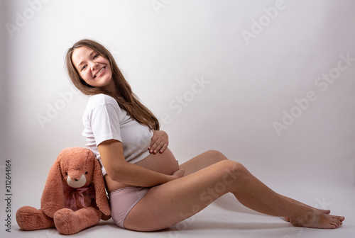 young pregnant woman sitting on white background