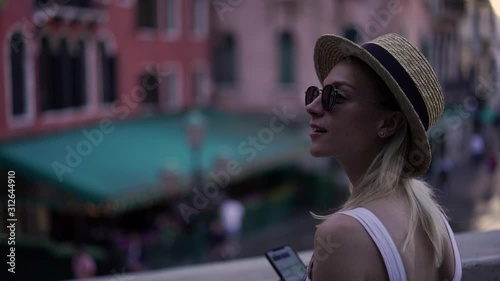 Slow motion effect of attractive caucasian female traveller enjoying time for exploring italian city walking on urban setting with modern smartphone gadget for tracking gps 