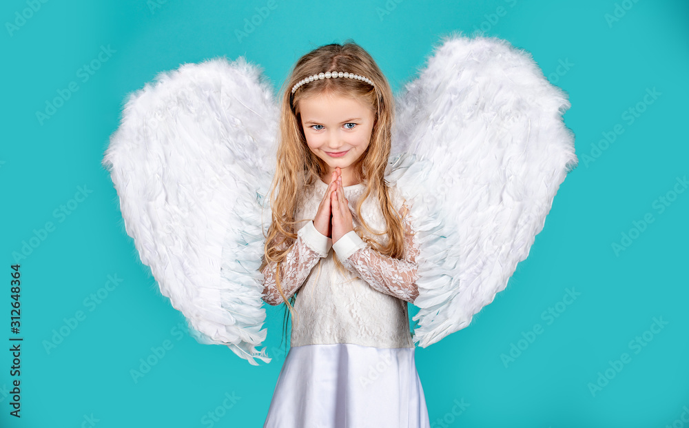 Child with angelic face. Cute child girl posing with angel wings. Beautiful little angel girl standing with your arms close to your chest as in prayer. Angels little hands crossed for you. Child with angelic face. Cute child girl posing with angel wings. Beautiful little angel girl standing with your arms close to your chest as in prayer. Angels little hands crossed for you.