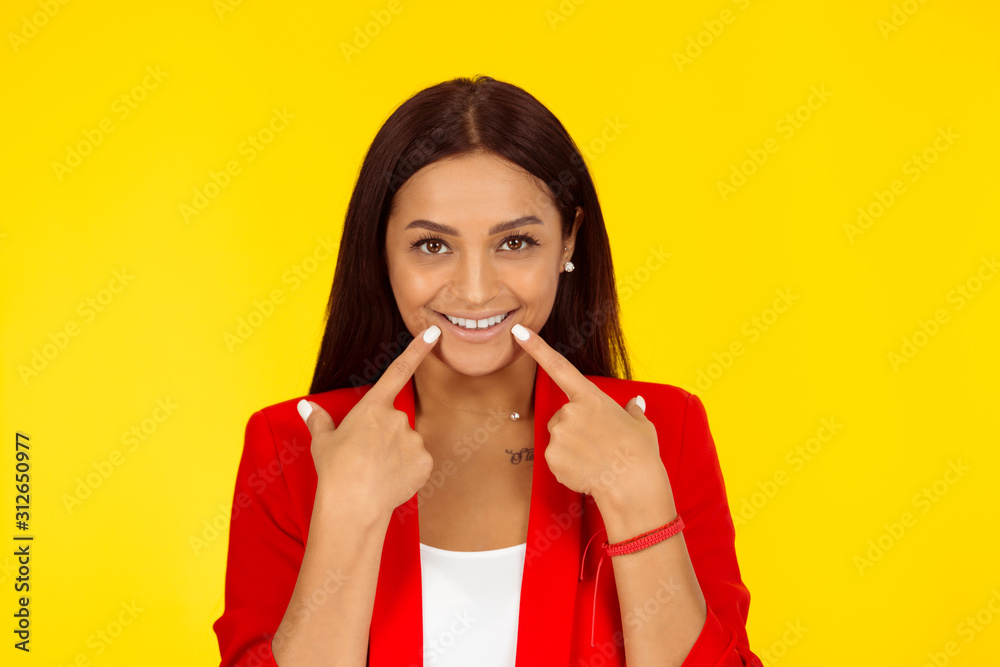 Woman showing perfect smile pointing with hand fingers Woman showing perfect smile pointing with hand fingers