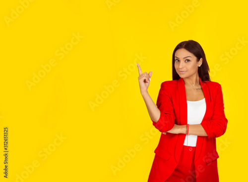 woman looking up pointing with finger at blank copy space