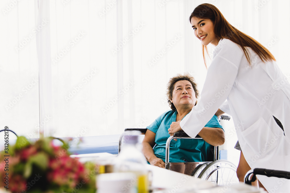 Beautiful female doctor Holding the hand of a old female patient at a wheelchair To encourage the sick Beautiful female doctor Holding the hand of a old female patient at a wheelchair To encourage the sick