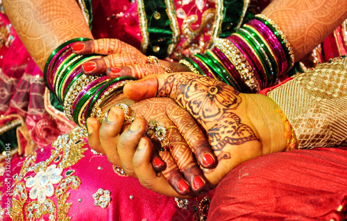 Photography bride and groom holding hands for traditional Hindu marriage