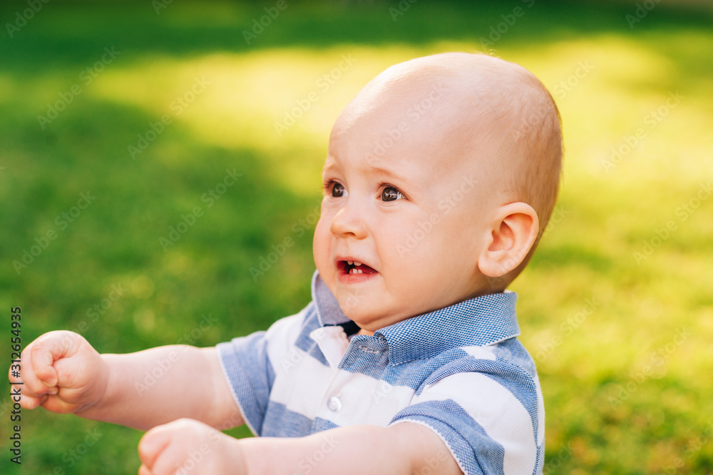 Outdoor portrait of adorable anxious baby boy playing in summer parc Outdoor portrait of adorable anxious baby boy playing in summer parc