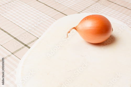 Onion for cooking on white board for cutting. photo