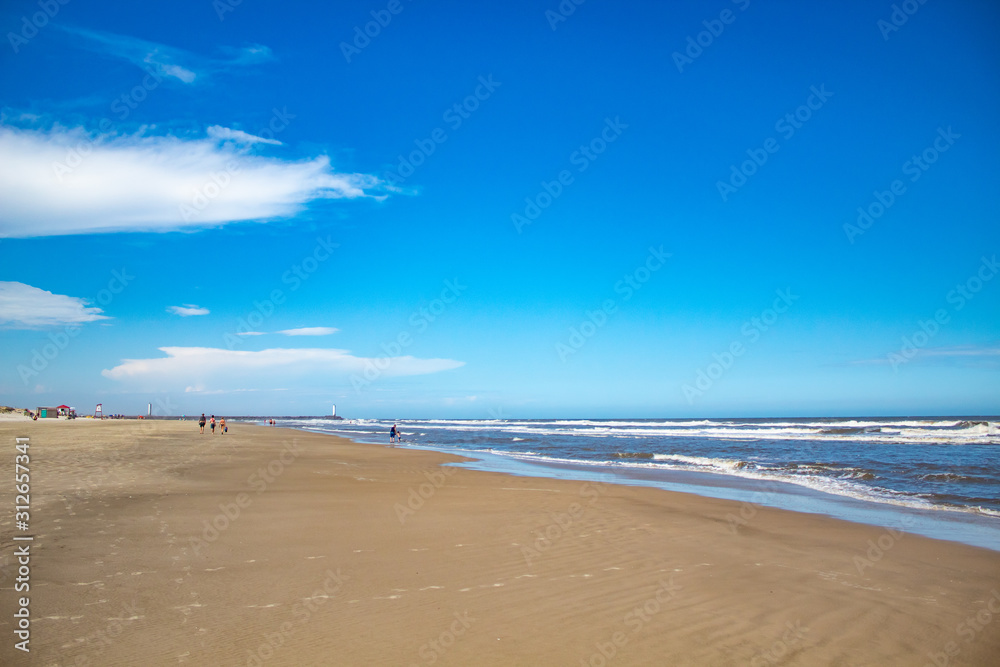 Lighthouse, sea and sand and the blue sky with clouds in Praia Grande, Torres city, Rio Grande do Sul state, Brazil