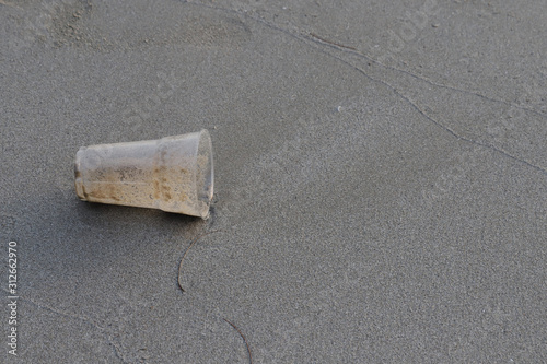 Plastic glass on the beach,garbage on the beach