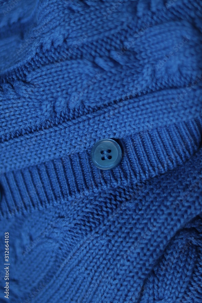 Seamless knitted fabric with pigtails. Knitted sweater with buttons. Knitted background. Classic Blue color 2020