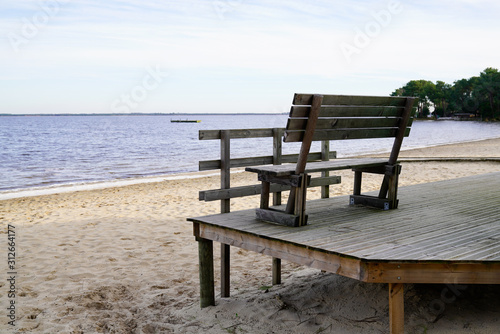 Sea view in wooden terrace with wood bench in sand lake beach © OceanProd