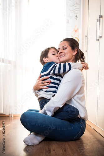 Young mom and her son hugging each other tightly. Mother kid relationship