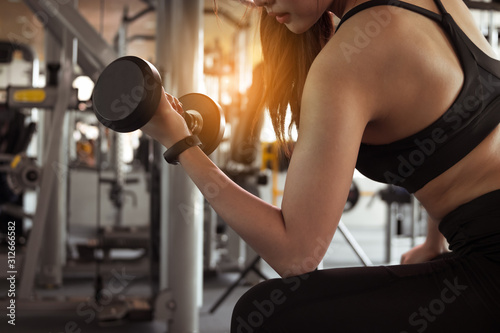 Fitness woman doing exercise workout dumbbell at gym. Healthy and lifestyle concept.