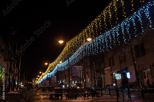 Christmas night neon glowing cityscape. Buildings with decorations and lamps. Minsk Belarus. December 31 2019